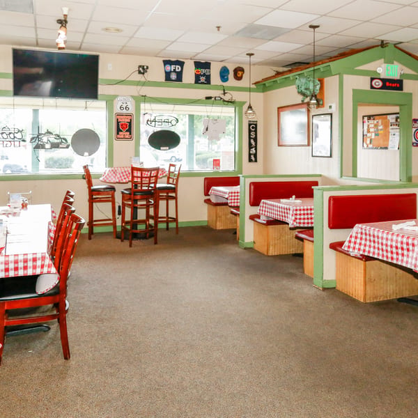 Diner interior with red and white checkered tablecloths, red booths, and Chicago Bears memorabilia.